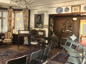 Besprechungsraum mit Sitzstühlen, Perserteppichen, alten Holzschränken und altmodischen Wandbehängen